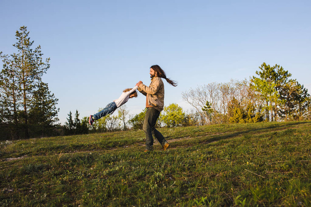 Father playing with daughter spinning around holding hands - Foto, Imagem