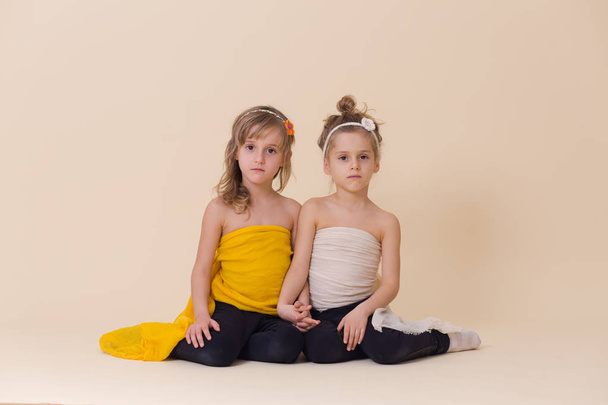 Két lány pózol együtt fantasy sárga és fehér ruhák - Fotó, kép