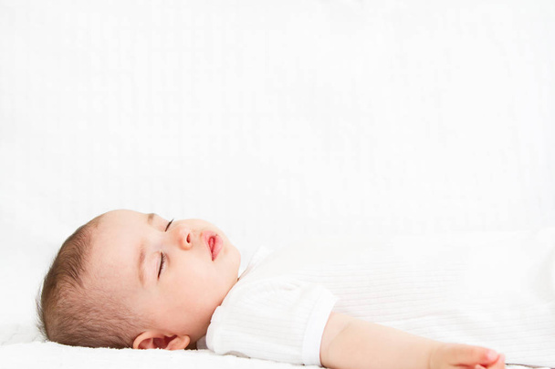 Close-up portrait of a beautiful sleeping baby on white bakcground - Foto, afbeelding