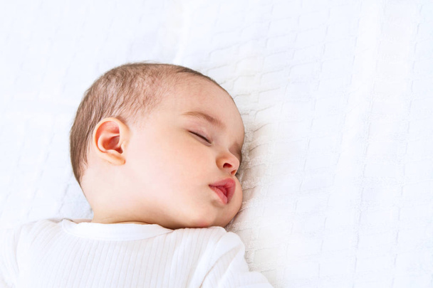 Close-up portrait of a beautiful sleeping baby on white bakcground - Фото, изображение
