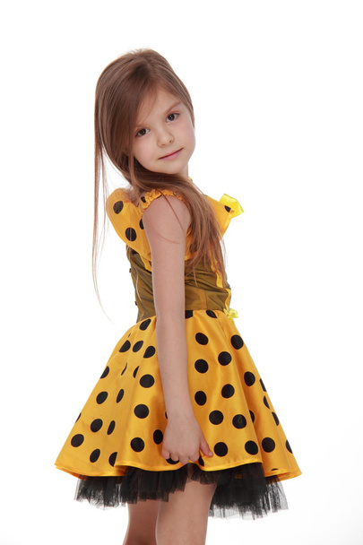 Charming emotional little girl in a yellow dress - Foto, Bild