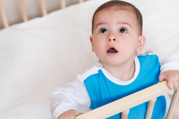 Intresting cute baby toddler look up on the white bed - Фото, зображення