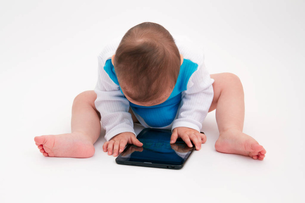 Adorable beautiful baby toddler look into the tablet on white background - Fotoğraf, Görsel