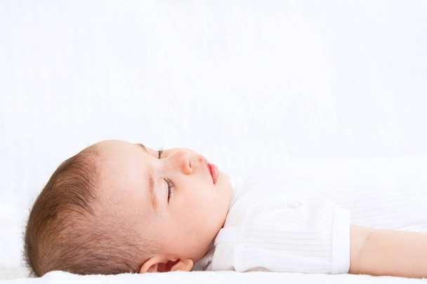 Nahaufnahme Porträt eines schönen schlafenden Babys auf weißem Bakkgrund - Foto, Bild