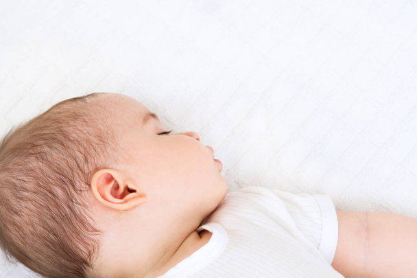 Close-up portrait of a beautiful sleeping baby on white bakcground - Foto, afbeelding