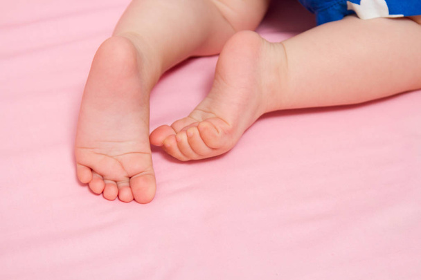 Lähikuva viehättävä pienet jalat vauvan vaaleanpunainen tausta
 - Valokuva, kuva