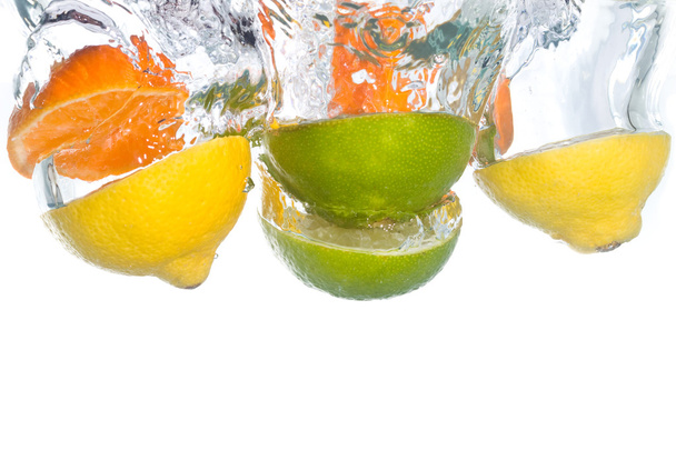 Citrus fruit falling into clear water - Photo, Image