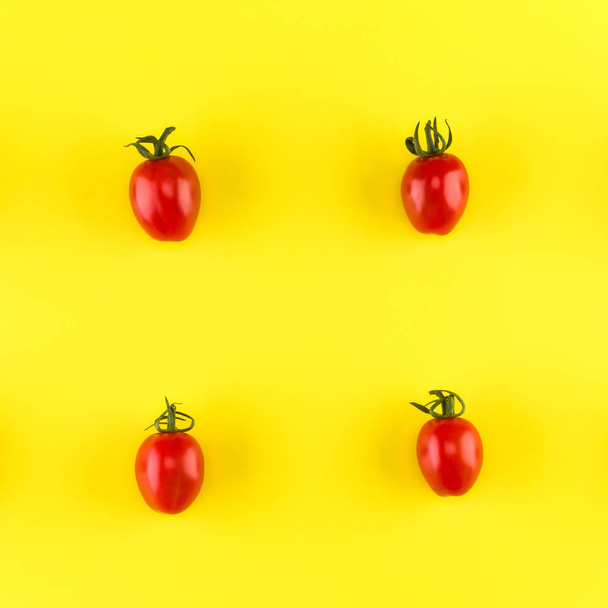 Food pattern of cherry tomato  isolated on yellow background. Flat lay, top view. - Foto, afbeelding