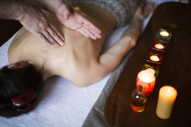 gentle hand massage of girl back. burning candles. Healthcare and relax concept - Photo, Image