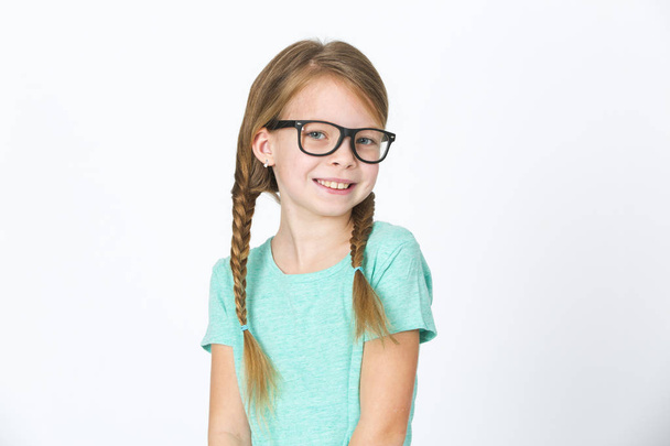 pretty girl with black glasses and plaits posing in front of white background in studio - Photo, Image