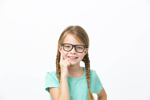 pretty girl with black glasses and plaits posing in front of white background in studio - Fotó, kép