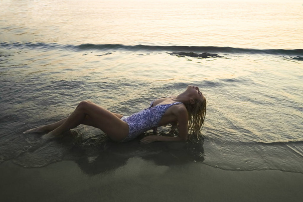 Приваблива струнка жінка відпочиває на пляжі лежить
.  - Фото, зображення