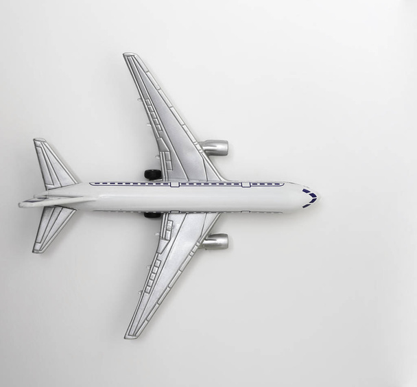 gray model airplane on grey background with copy space.  flat lay design  - Zdjęcie, obraz