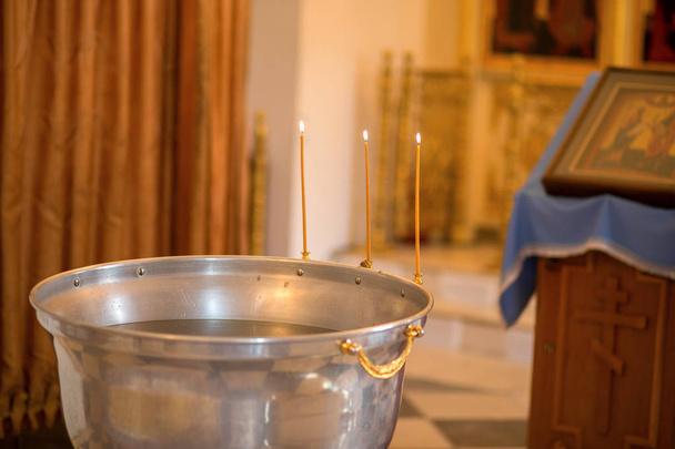 Czcionki z wodą święconą na sprawowaniu sakramentu chrztu dziecka, Świątynia - Zdjęcie, obraz
