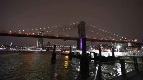 Noční pohled na Manhattan a Brooklyn mosty, široký úhel pohledu z Brooklyn Bridge Park, New York City - Záběry, video