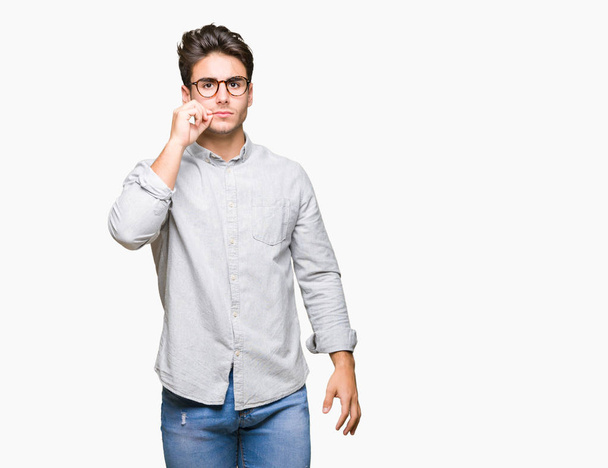 Young handsome man wearing glasses over isolated background mouth and lips shut as zip with fingers. Secret and silent, taboo talking - Photo, Image