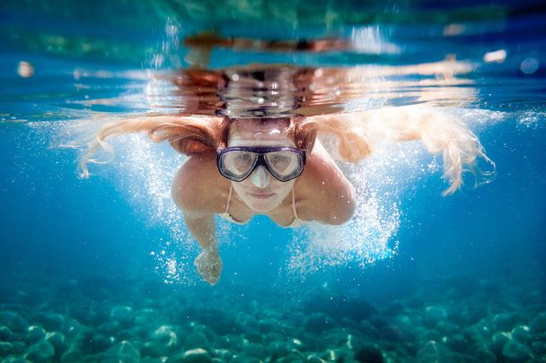 Young woman snorkeling underwater in the clear tropical water - Photo, image