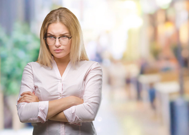 Young caucasian business woman wearing glasses over isolated background skeptic and nervous, disapproving expression on face with crossed arms. Negative person. - Фото, зображення