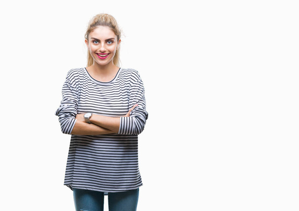 Giovane bella donna bionda che indossa maglione a righe su sfondo isolato volto felice sorridente con le braccia incrociate guardando la fotocamera. Persona positiva
. - Foto, immagini