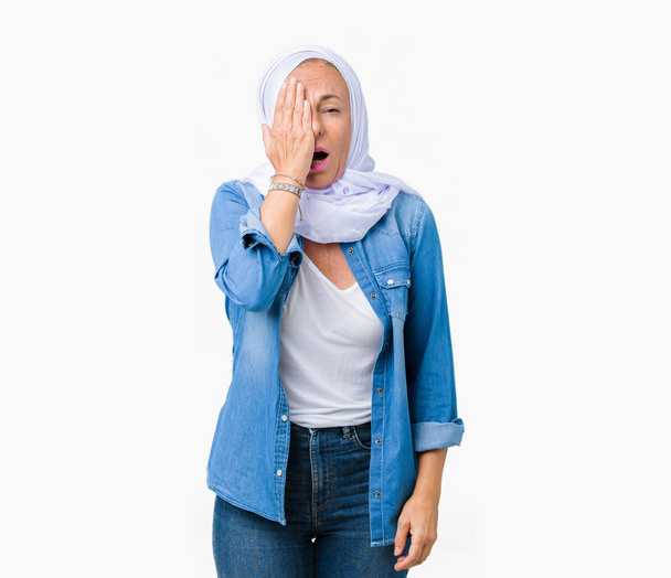 Середньовіччя східна арабська жінка в арабському хіджабі над ізольованим тлом Яунінг втомився покривати половину обличчя, очі і рот рукою. Болить обличчя від болю
. - Фото, зображення