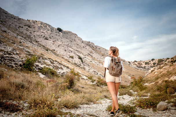 Beautiful tourist girl on hiking trail in mountain looking at landscape - Foto, Bild