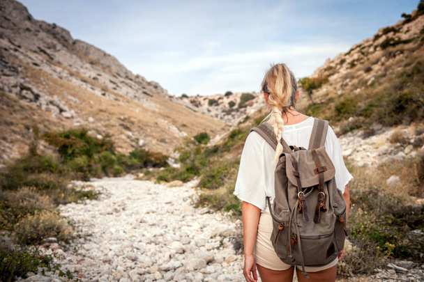 Hiker girl with backpack on hiking trail in mountain, trekking and travel lifestyle concept - Foto, imagen