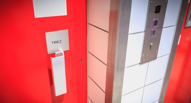 czerwone metalowe drzwi windy, gdzie jest napisane ciągnąć w języku francuskim - Zdjęcie, obraz