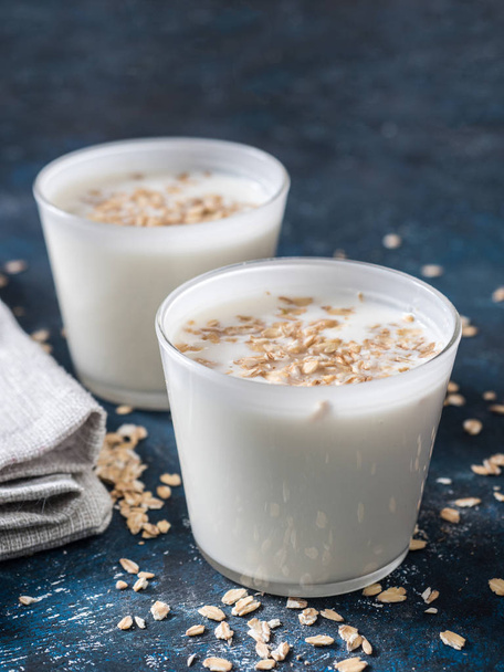 Healthy breakfast. Yogurt with oat flakes in white glasses on a blue background. - Fotografie, Obrázek