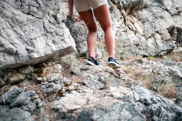 Beine von Wanderin beim Wandern in der Nähe von Felsen - Foto, Bild