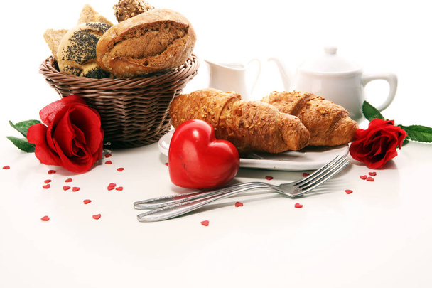 breakfast on table with bread buns, croissants, jam, coffe and juice on valentines day - Foto, afbeelding