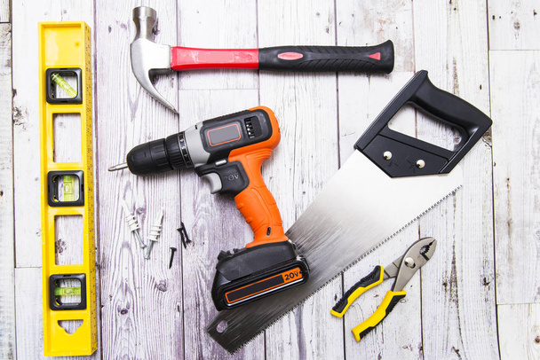 screwdriver, level, hammer, on a white wooden background close-up - Foto, imagen