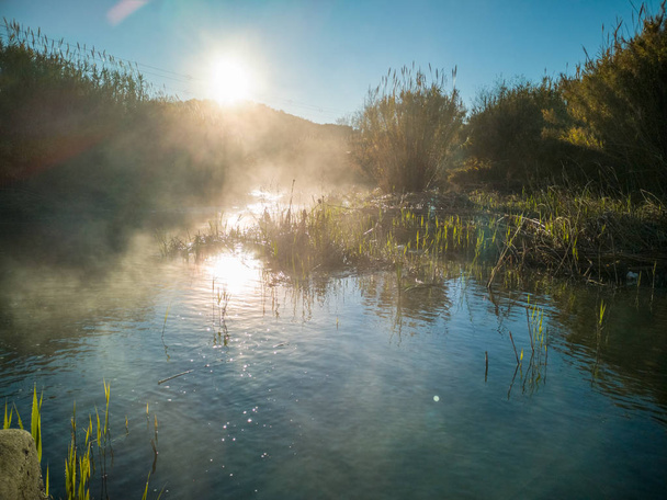 Joki, jossa vesi haihtuu kylmänä aamuna vuorella
 - Valokuva, kuva
