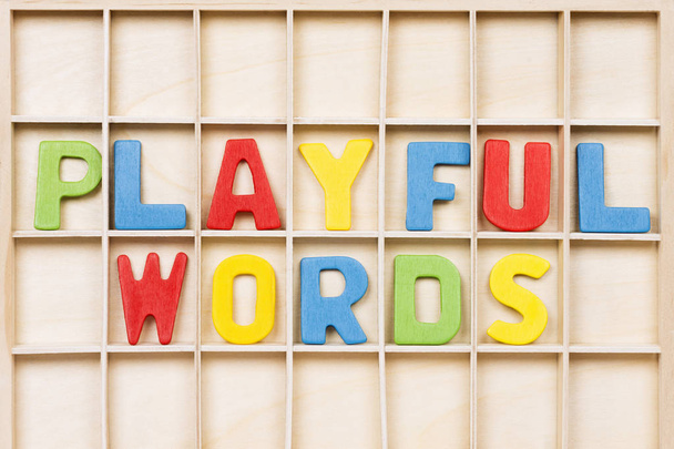 Παιχνιδιάρικες λέξεις κείμενο από πολύχρωμα ξύλινα γράμματα είναι σε ξύλινο φόντο, εκπαίδευση, μαθαίνοντας Αγγλικά ή μητρική γλώσσα έννοια. - Φωτογραφία, εικόνα