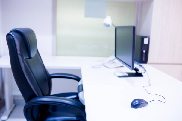 コンピューターは、明るいインテリアのテーブルの上です。白いマネージャー デスクと pc とマウスのオフィスで黒の回転椅子. - 写真・画像
