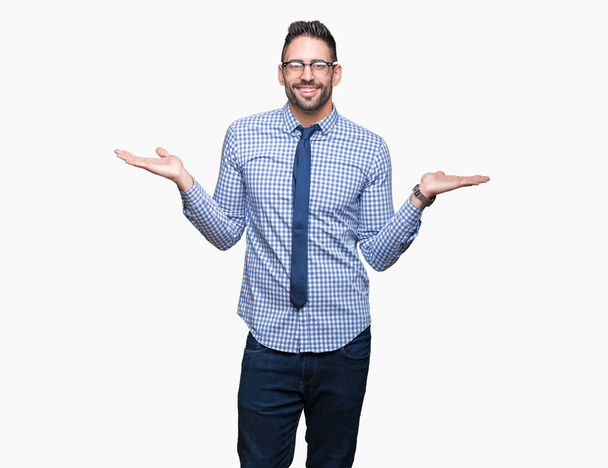 Joven hombre de negocios con gafas sobre fondo aislado Sonriendo mostrando ambas manos palmas abiertas, presentando y comparando publicidad y equilibrio
 - Foto, imagen