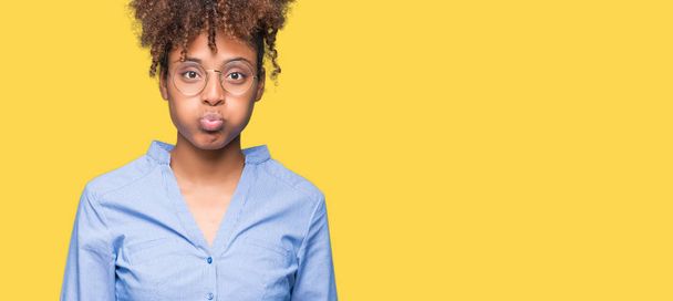Красива молода афроамериканська бізнес-леді над ізольованим фоном набиває щоки смішним обличчям. Рот, надутий повітрям, божевільний вираз
. - Фото, зображення