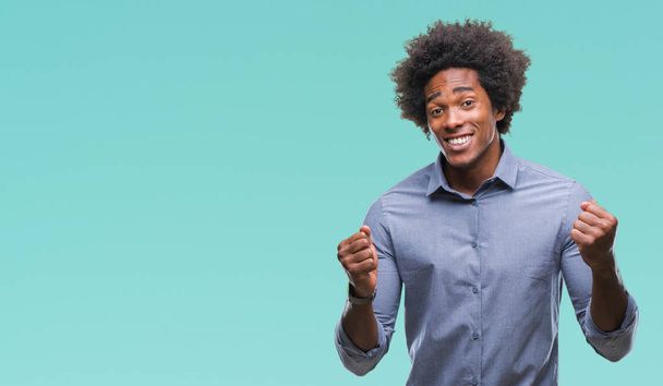 Afro-Américain sur fond isolé très heureux et excité de faire geste gagnant avec les bras levés, souriant et criant pour le succès. Concept de célébration
. - Photo, image