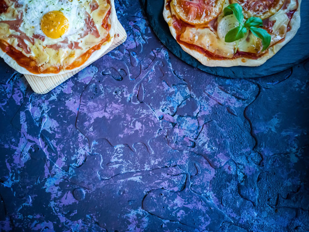 Homemade pizzas and utensils on dark background in lilac tones - Photo, Image