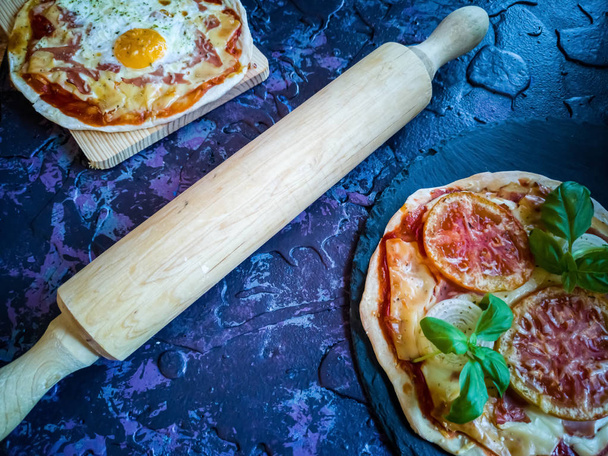 Homemade pizzas and utensils on dark background in lilac tones - Photo, Image