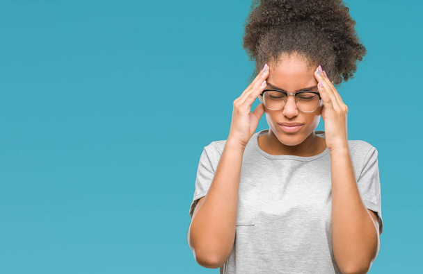 Jonge afro Amerikaanse vrouw bril geïsoleerd achtergrond met hand op het hoofd voor pijn in hoofd, omdat stress. Lijden van migraine. - Foto, afbeelding