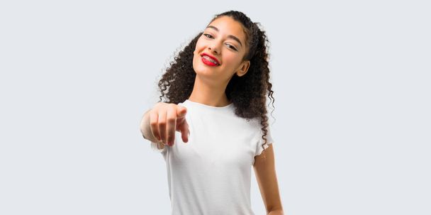 Young girl with curly hair pointing with finger at someone and laughing a lot on grey background - Foto, Bild