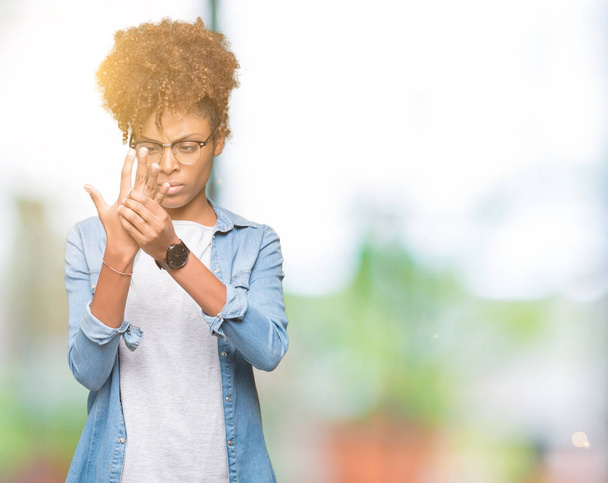 Mooie jonge african american vrouw het dragen van bril over geïsoleerde achtergrond lijden pijn op handen en vingers, artritis ontsteking - Foto, afbeelding
