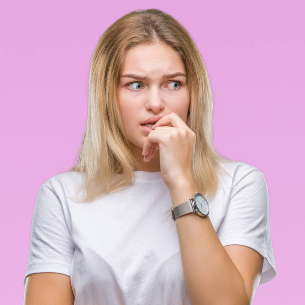 Young caucasian woman over isolated background looking stressed and nervous with hands on mouth biting nails. Anxiety problem. - Photo, image
