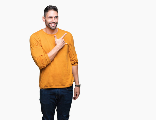 Young handsome man over isolated background cheerful with a smile of face pointing with hand and finger up to the side with happy and natural expression on face - Фото, зображення