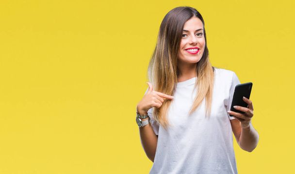 Молодая взрослая женщина показывает экран смартфона очень счастливо указывая рукой и пальцем в сторону
 - Фото, изображение