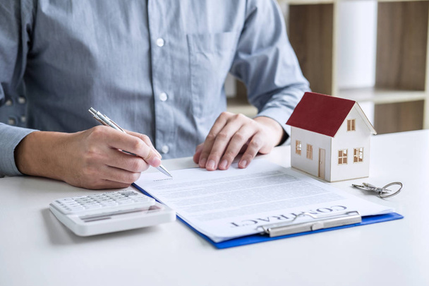 Businessman working doing finances and calculation cost of real estate investment while be signing to contract, Concept mortgage loan approval. - Photo, image