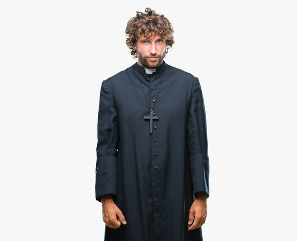 Handsome hispanic catholic priest man over isolated background depressed and worry for distress, crying angry and afraid. Sad expression. - Фото, изображение