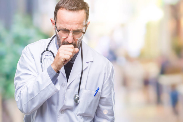 Hombre médico de edad madura con uniforme médico aislado sensación de malestar y tos como síntoma de resfriado o bronquitis. Concepto sanitario
. - Foto, Imagen