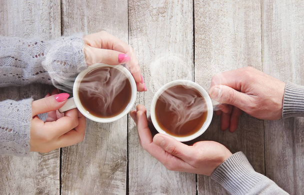 Una taza de té en las manos de un hombre y una mujer. Enfoque selectivo. lindo
. - Foto, Imagen