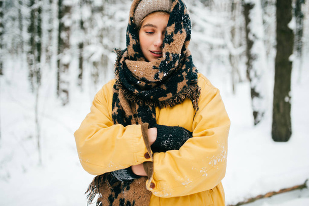 portrait of beautiful woman with scarf in winter forest - Фото, изображение